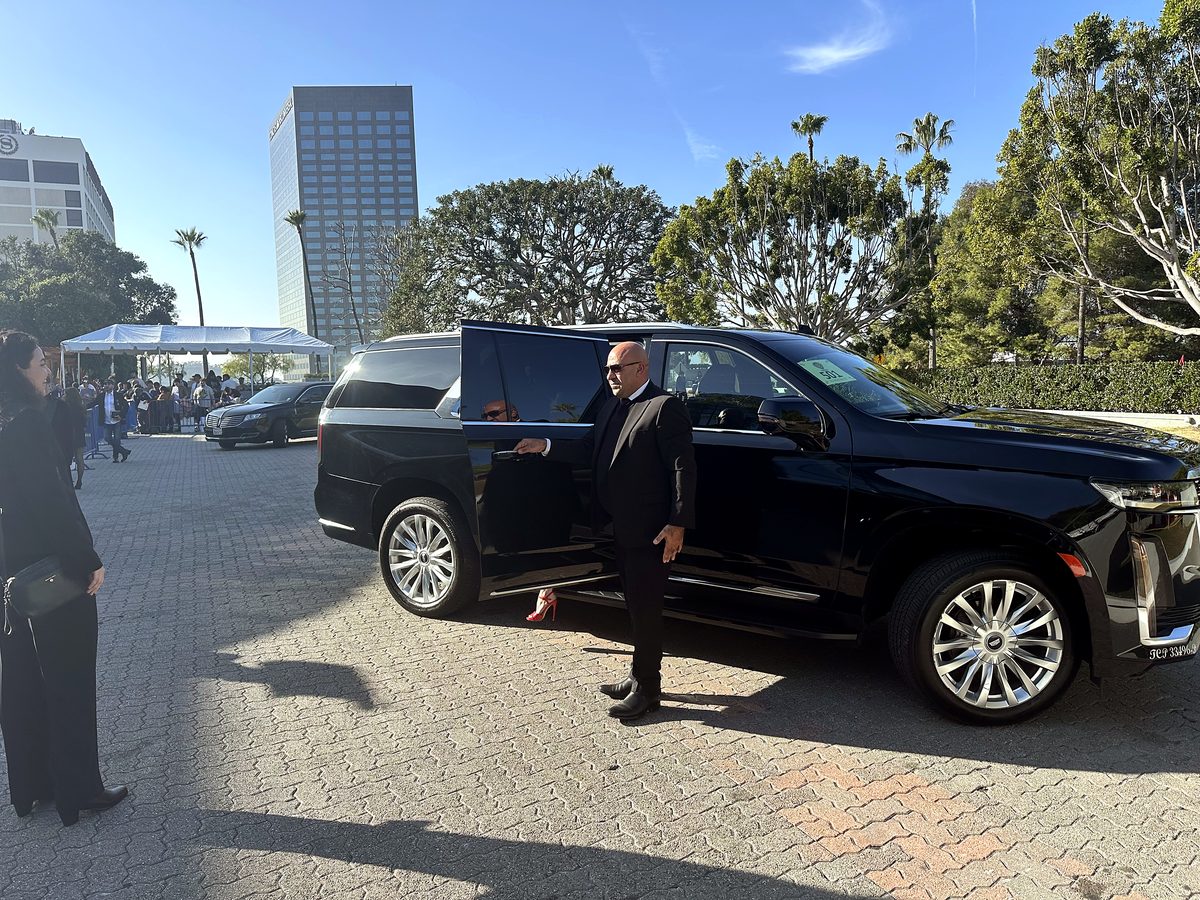 Chauffeur holding the door of the Escalade ESV