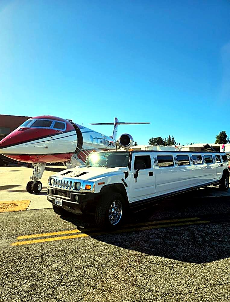 Hummer H2 stretch limo next to a private jet